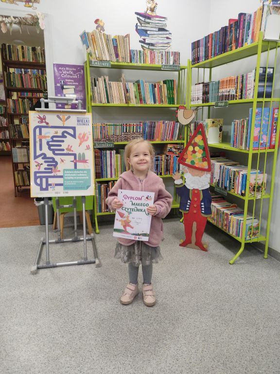 Mała dzieczynka z dyplomem Małego Czytelnika
