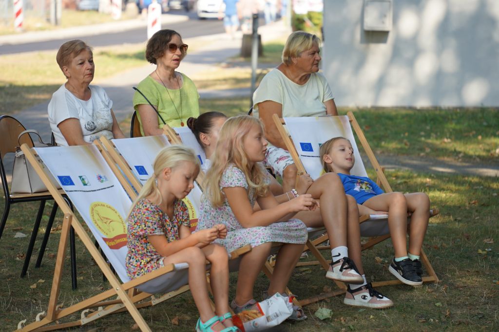 Dzieci słuchają czytania na leżakach