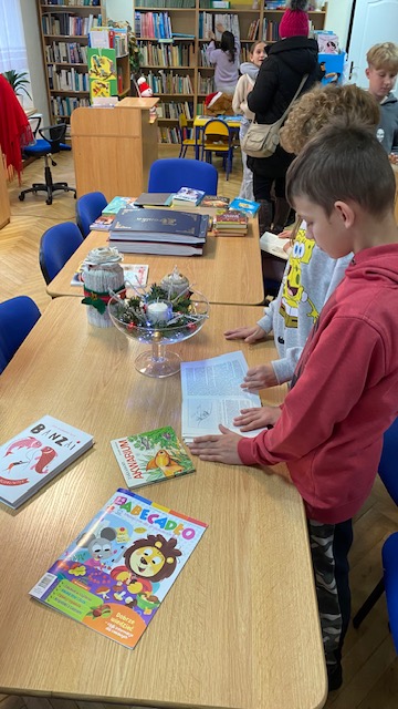 Dzieci siedzą przy stole w czasie lekcji bibliotecznej