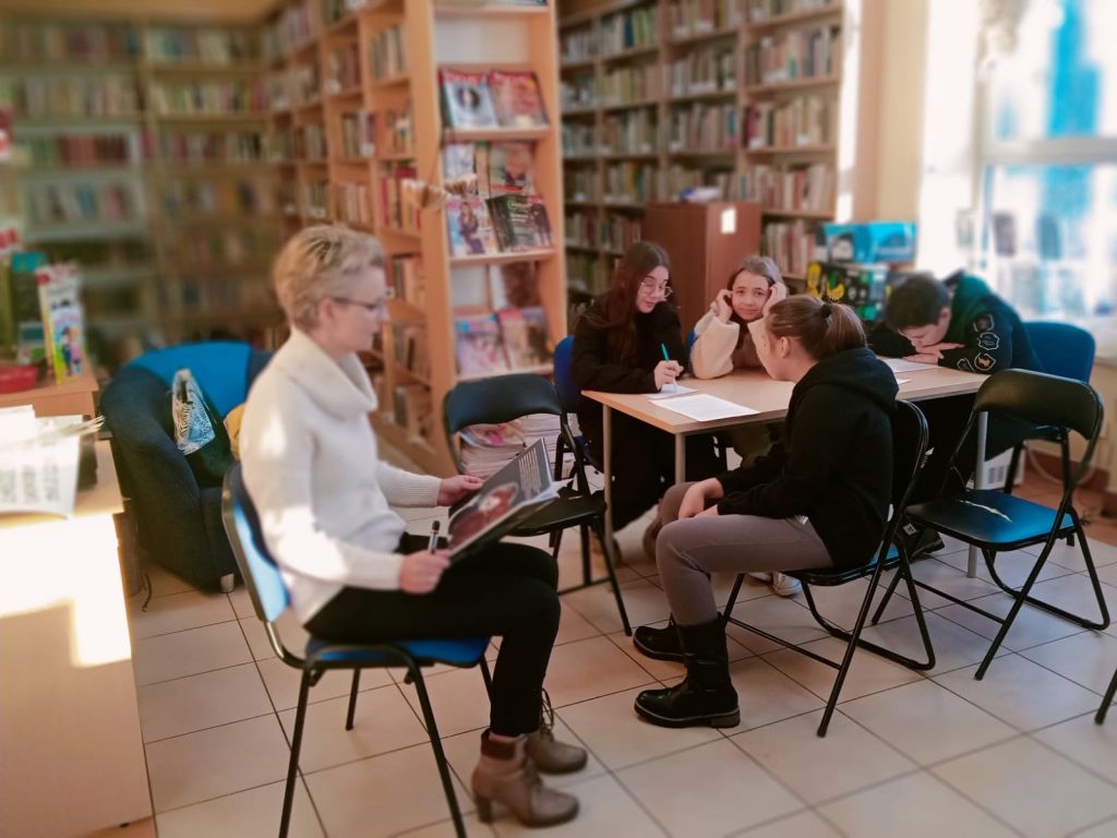 Bibliotekarz czyta dzieciom na głos książkę