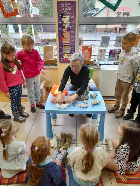 Dzieci oglądają różnego rodzaju kamienie, które leżą na stoliku