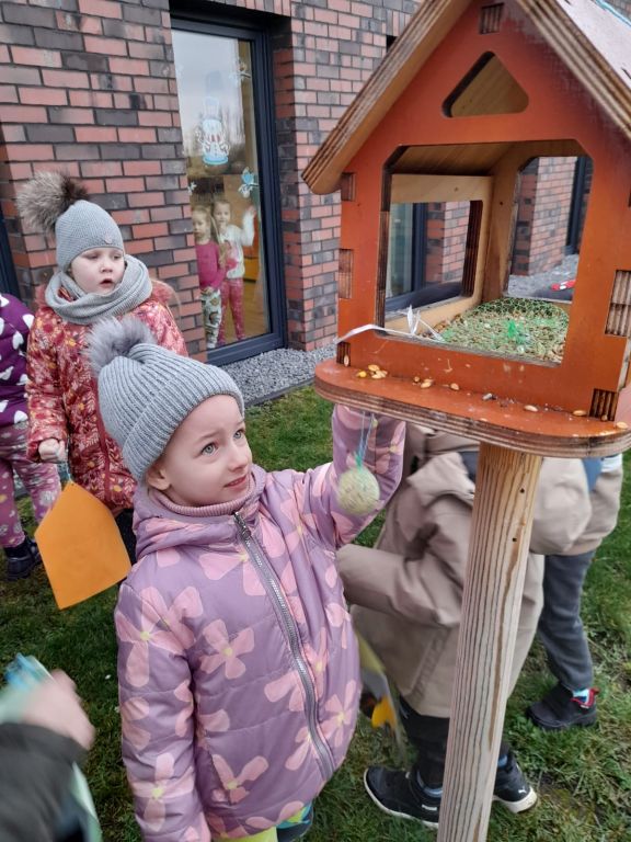 Dzieci na dworze dotykają prawdziwego karmnika