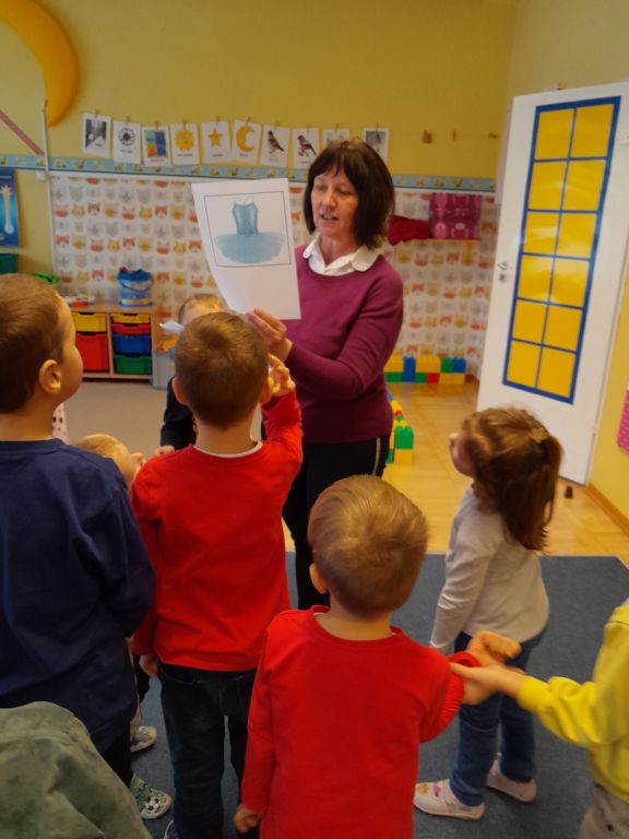 Bibliotekarz pokazuje dzieciom obrazek stroju prawdziwej baletnicy