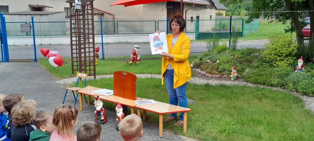 Bibliotekarz przedstawia dzieciom ilustracje innych krasnali i skrzatów