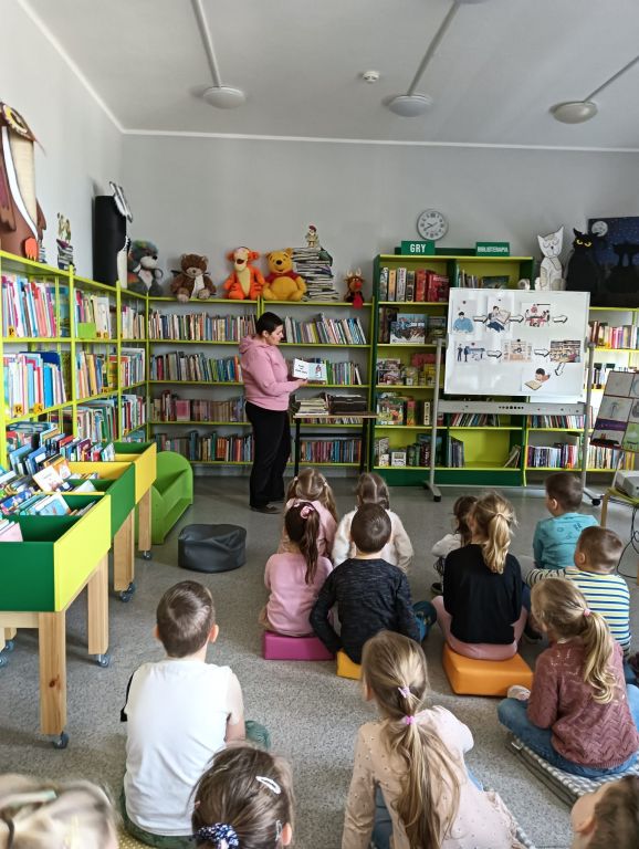 Bibliotekarz pokazuje dzieciom książkę zabawkę