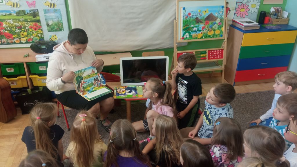 Bibliotekarz pokazuje dzieciom ciekawe książki