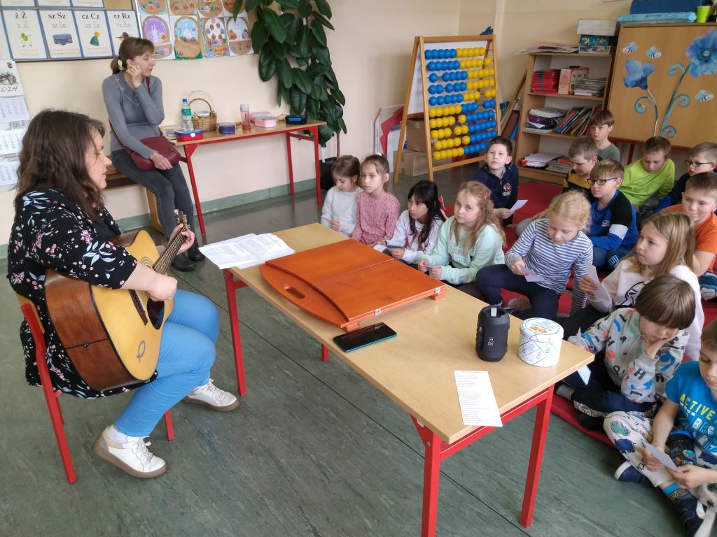 Dzieci śpiewają, bibliotekarz gra na gitarze