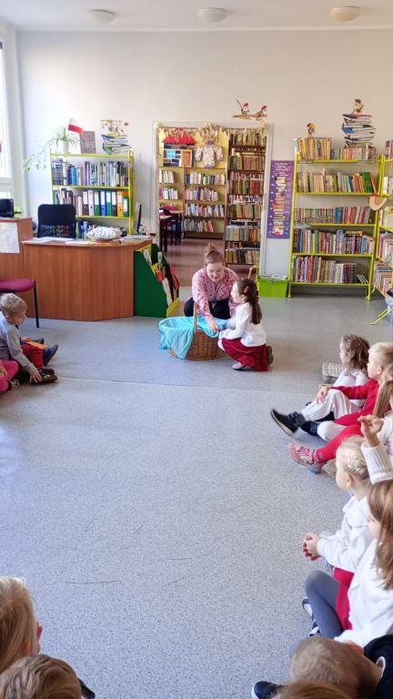 Dziewczynka szuka w koszyku przedmiotu związanego z postacią z bajki