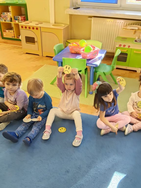 Dzieci pokazują bużkę smutną lub wesołą w zależności czy zgadzają się z zasadą