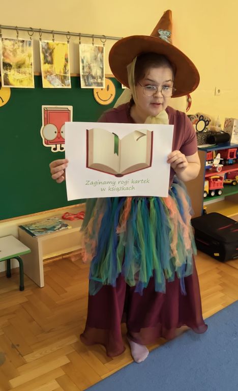 Bibliotekarka pokazuje ilustracje związane z zasadami korzystania z książek