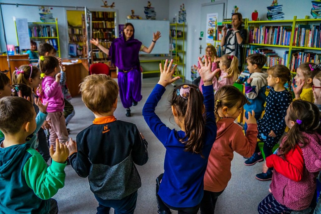 Dzieci w kole naśladują ruchy bibliotekarza