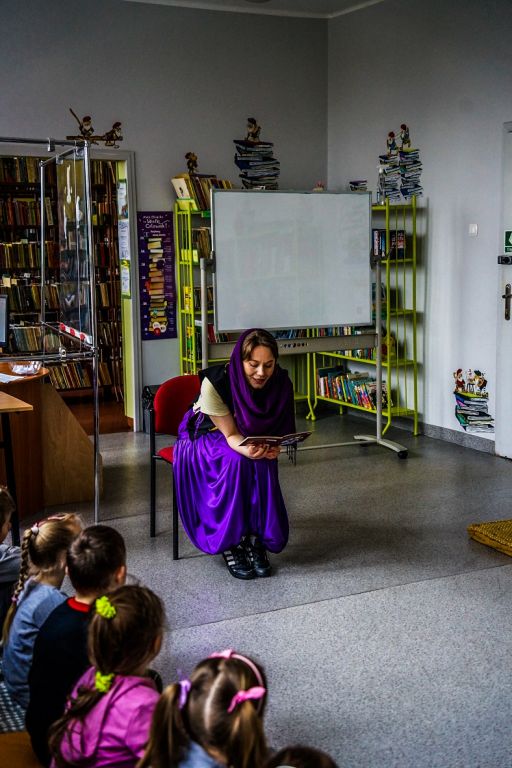 Bibliotekarz przebrany za maga czyta dzieciom bajkę