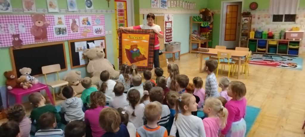 Zamiast pluszaka bibliotekarka pokazuje kocyk z wizerunkiem misia