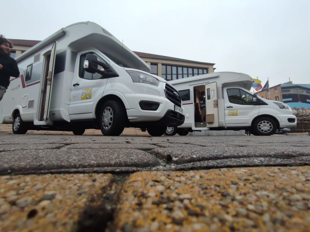 Dwa białe kampery stojące obok siebie