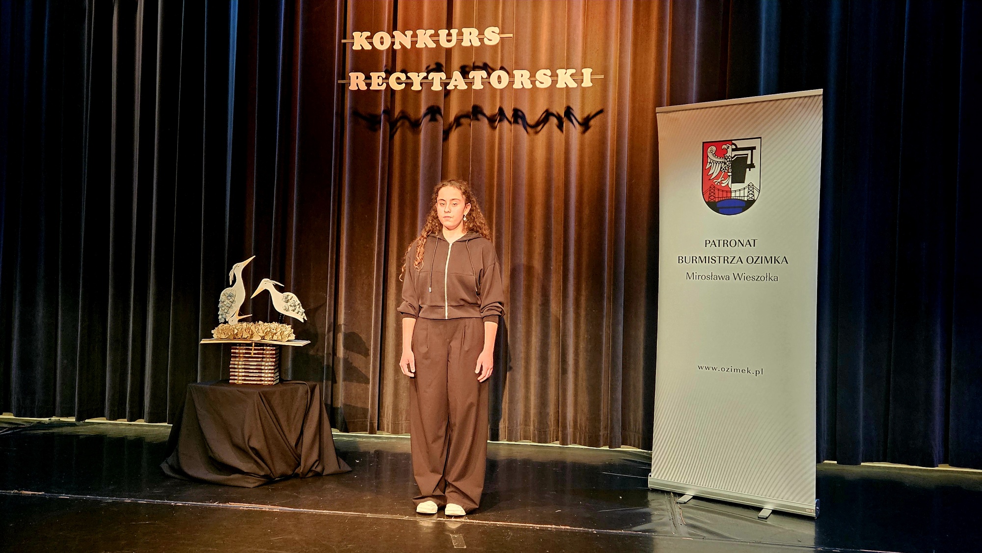Dziewczyna recytuje wiersz na scenie