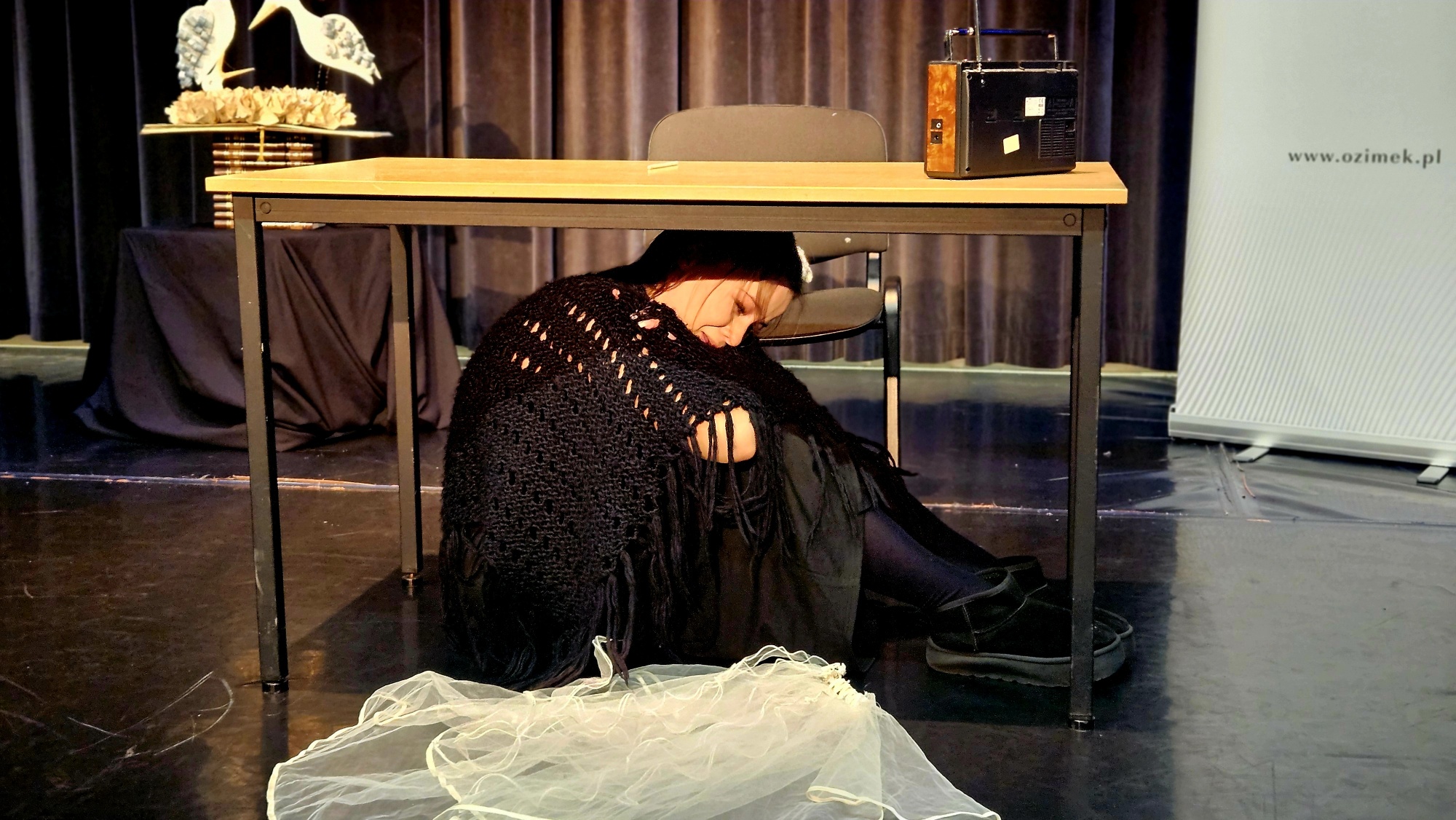 Dziewczyna siedzi pod stołem