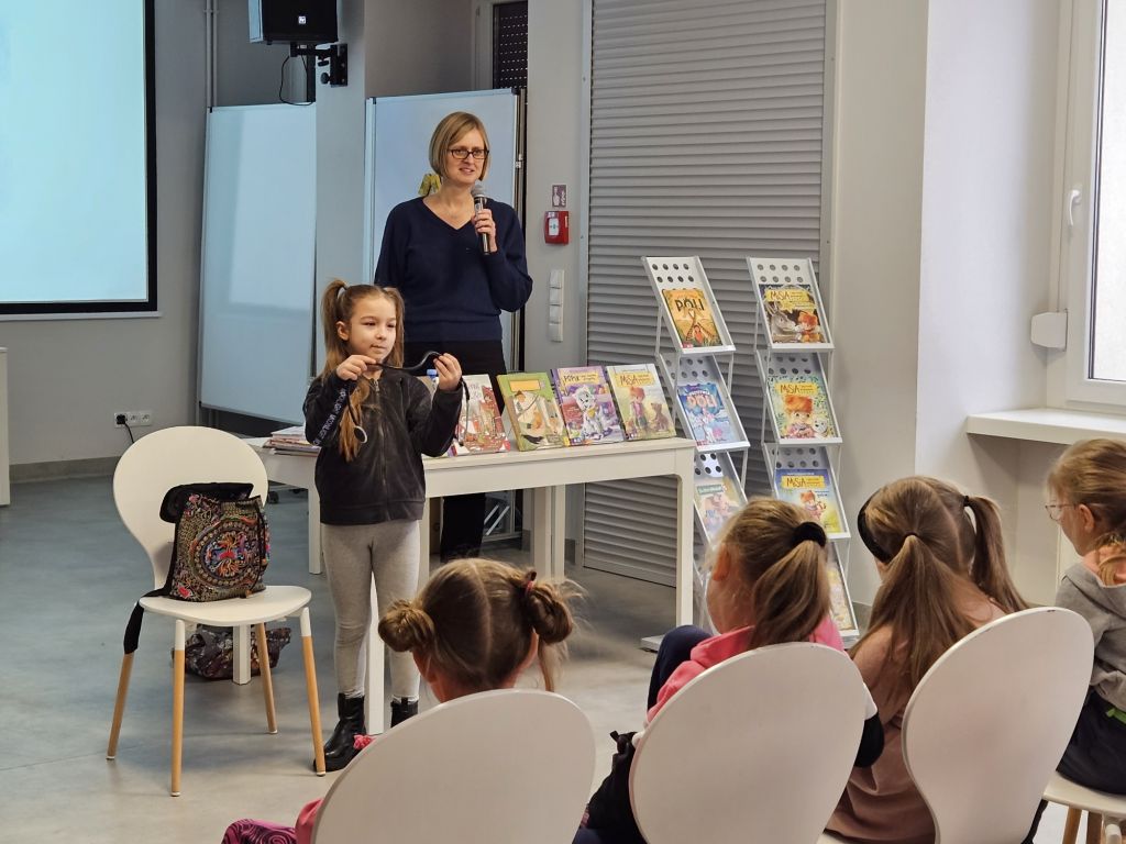 Dziecko i prowadząca stoją na środku