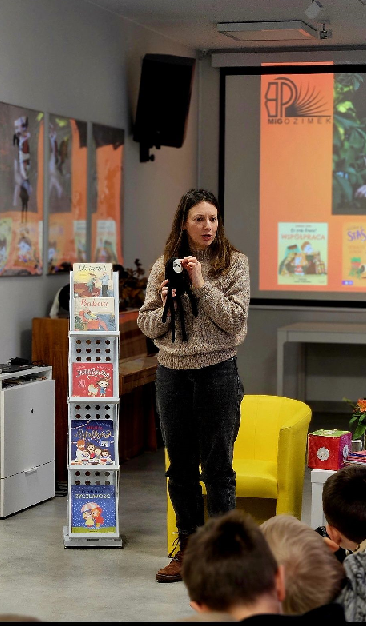 Barbara Supeł pokazuje dzieciom maskotkę leniwca