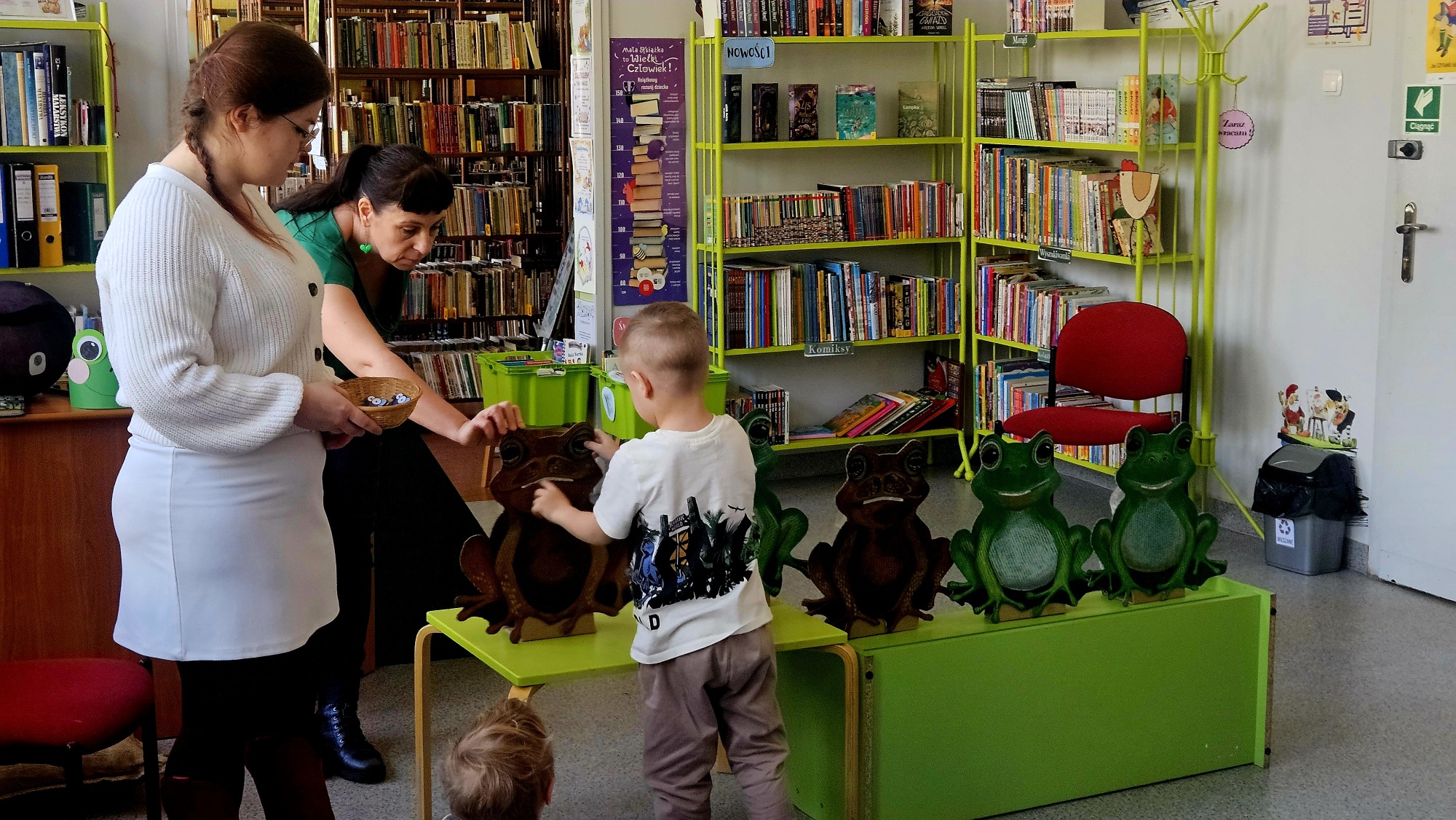 Chłopiec karmi kartonowe żaby muchami