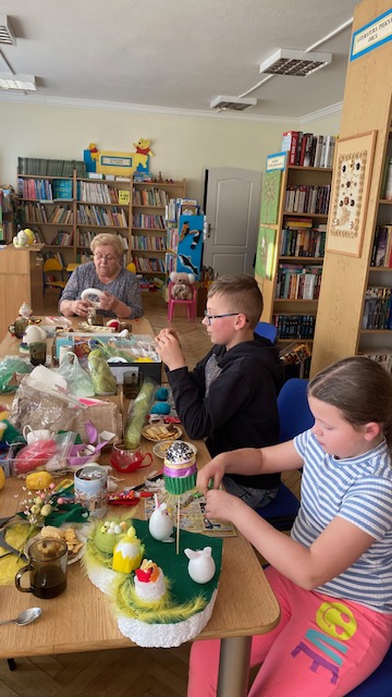 Uczestnicy warsztat&oacute;w pracują przy stole