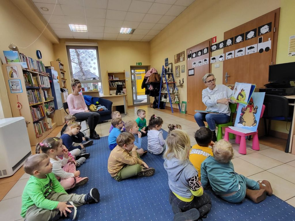 Dzieci siedzą na pufkach