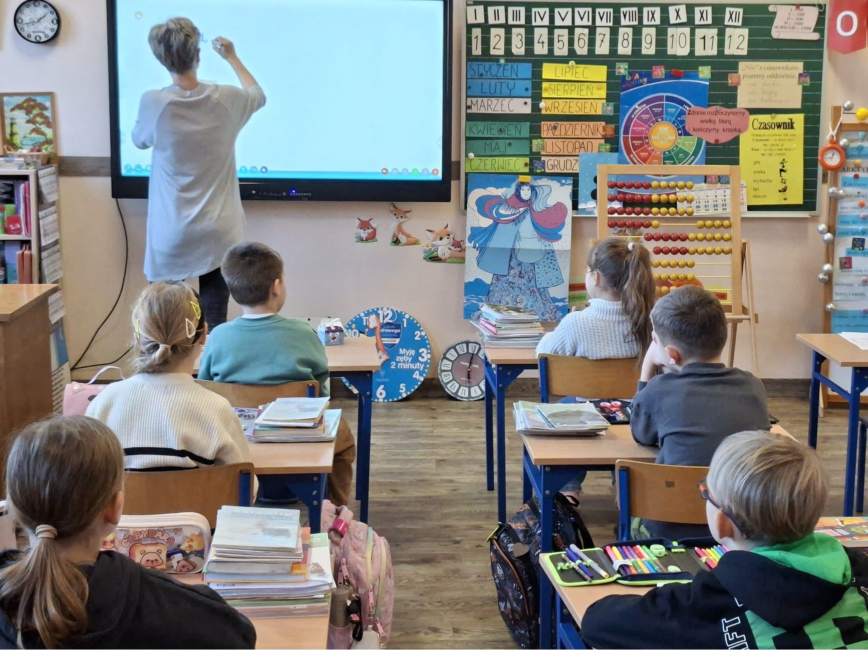 Bibliotekarz pisze na tablicy elektronicznej