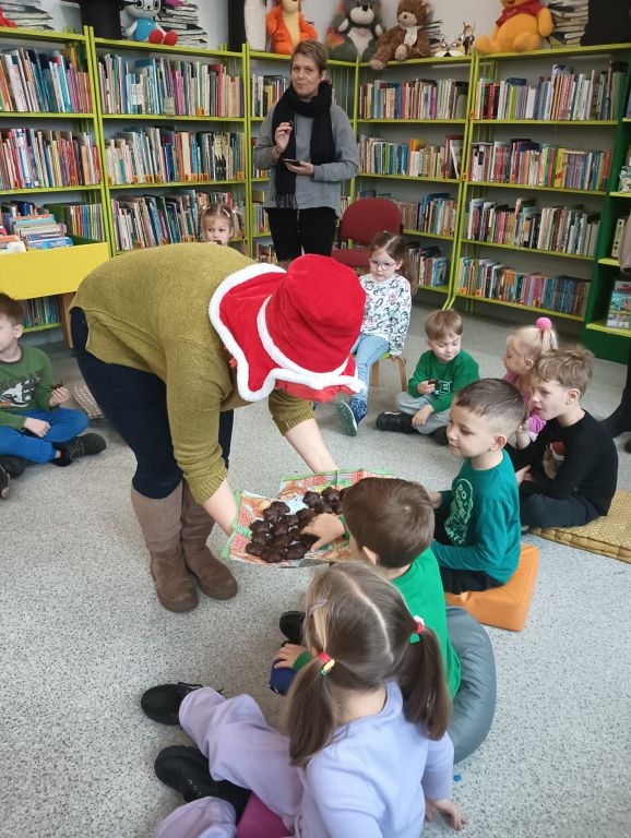Bibliotekarka częstuje dzieci pierniczkami