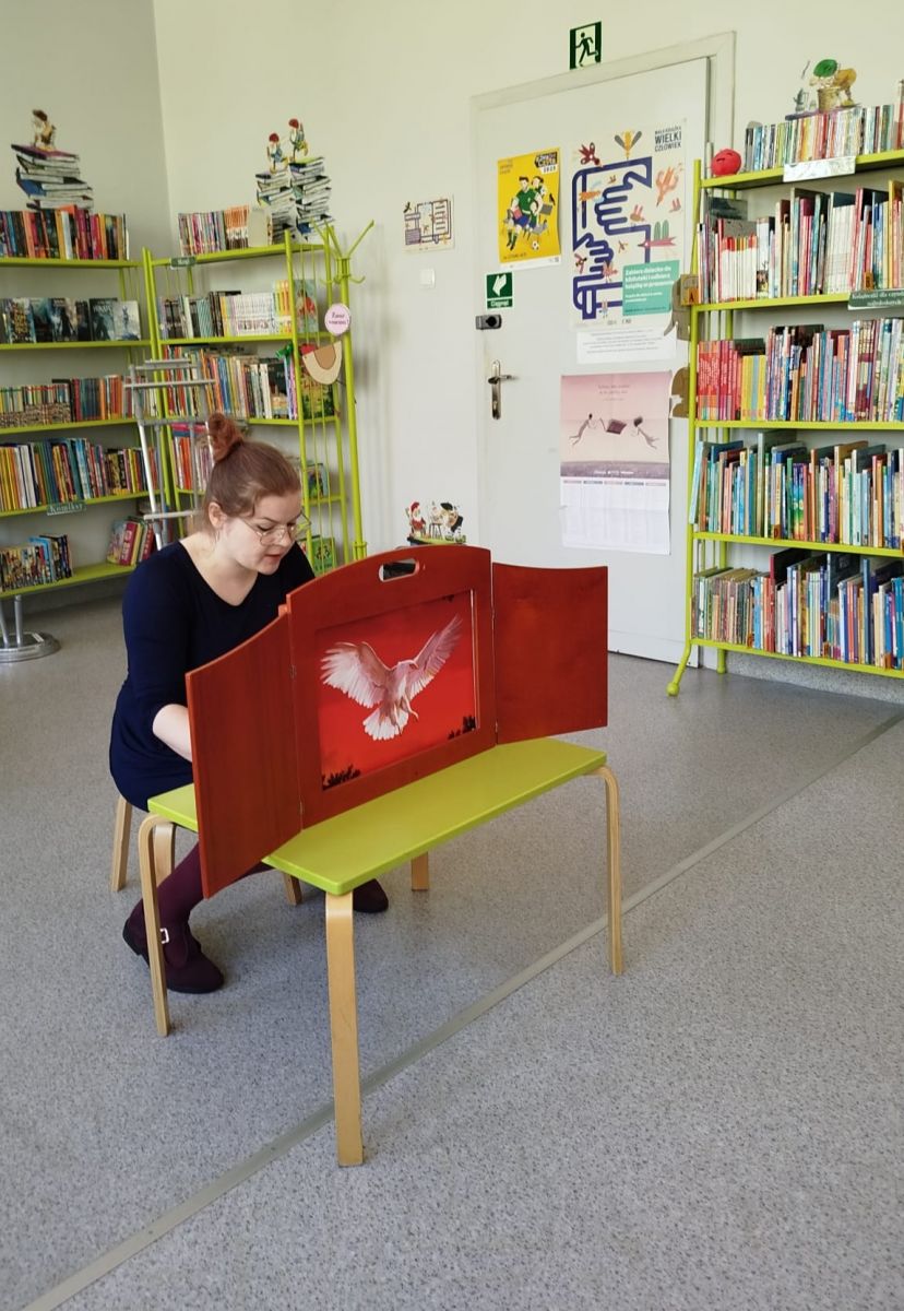 Bibliotekarka czyta teatrzyk kamishibai pt. "Legenda o Lechu, Czechu i Rusie".
