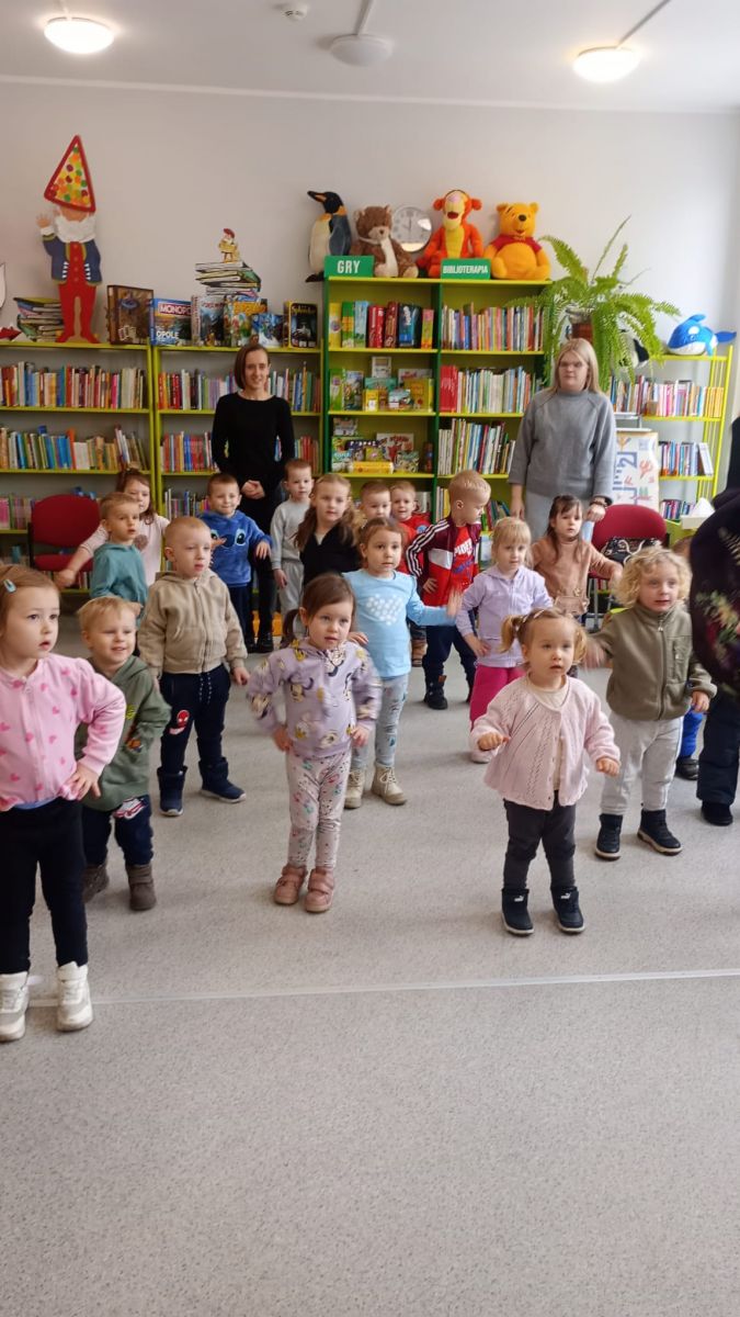 Grupa dzieci tańczy do muzyki udając roboty.