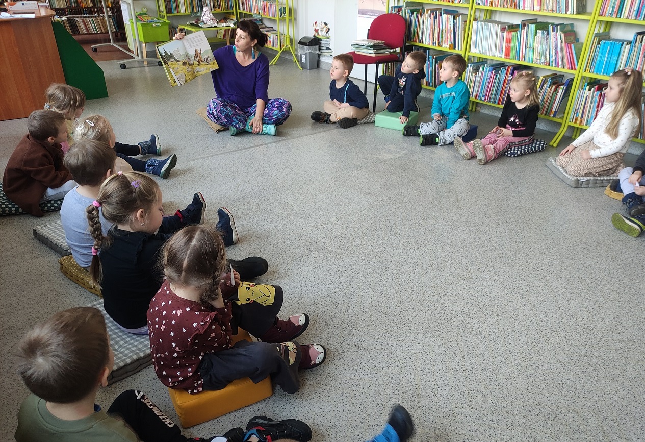 Pani czyta książkę dzieciom.