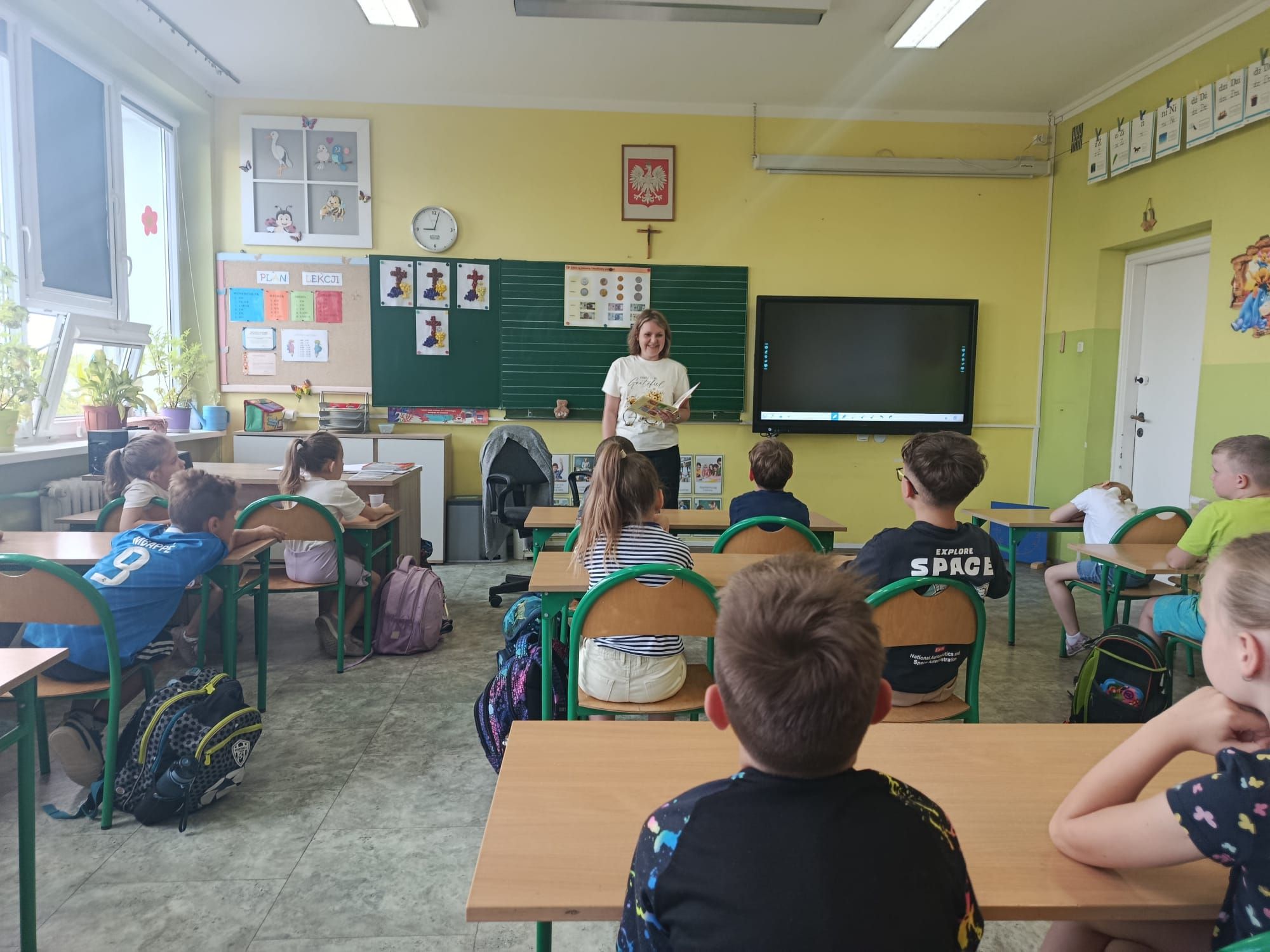 Prowadząca pokazuje książkę, z kt&oacute;rej będzie czytała opowiadanie