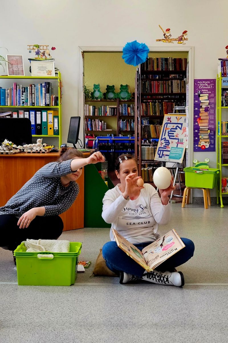 Bibliotekarki pokazują dzieciom na przykładach r&oacute;żnice w wielkości ptasich jaj.