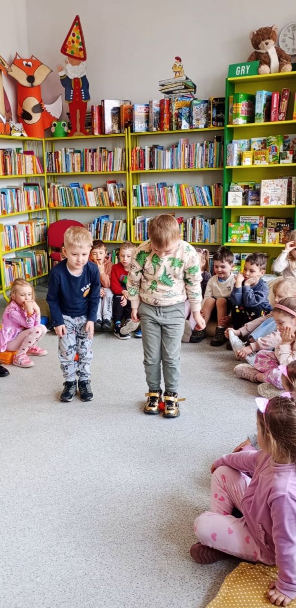 Dw&oacute;ch chłopc&oacute;w pr&oacute;buje przejść się z jajkami umieszczonymi między kostkami ich st&oacute;p.