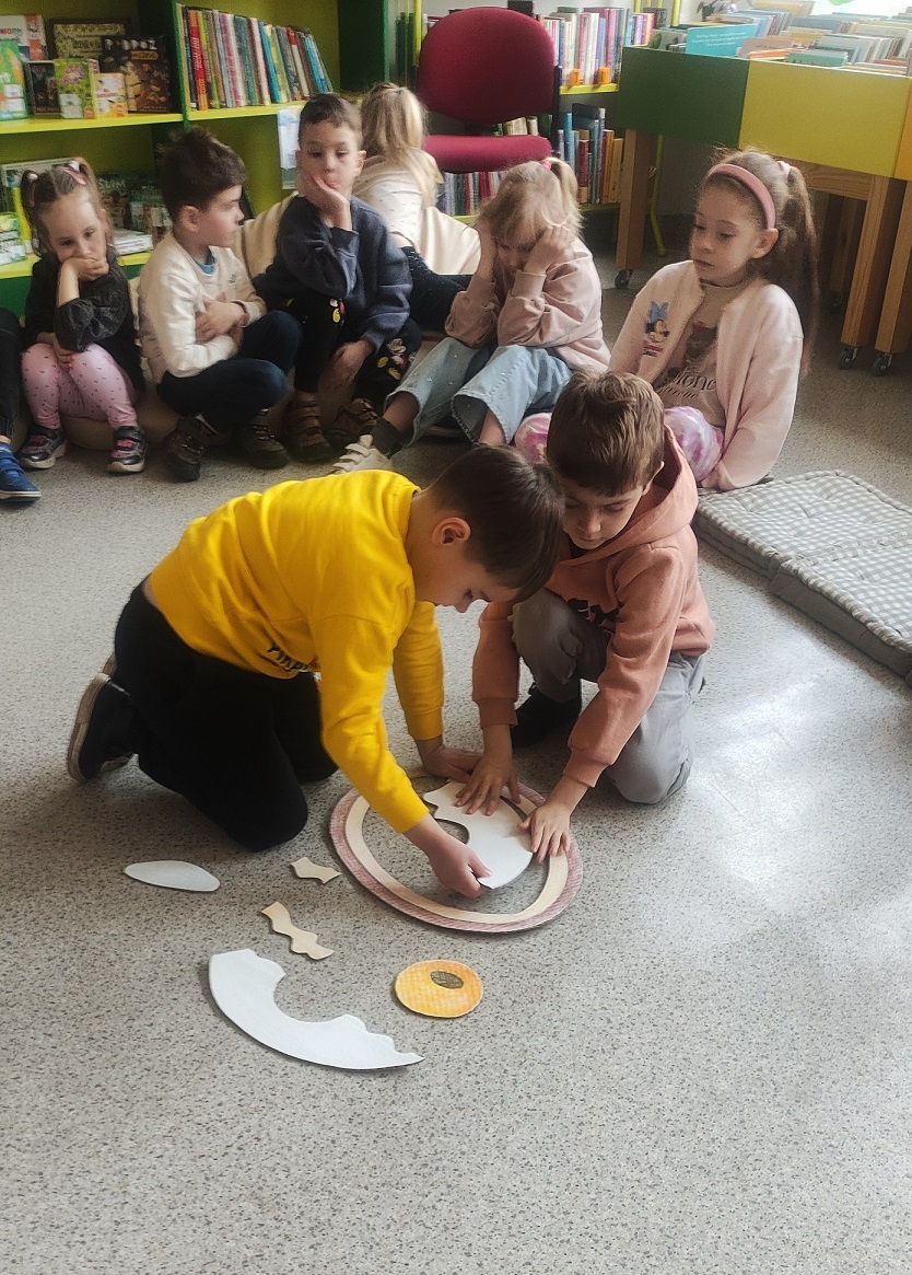 Dw&oacute;ch chłopc&oacute;w układa puzzle tak, aby powstał z nich obraz przekroju budowy jajka.