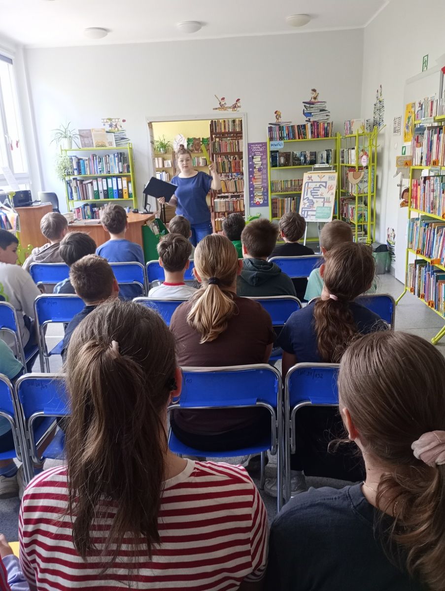 Bibliotekarka zwr&oacute;cona do dzieci opowiada im o najważniejszych zasadach panujących w bibliotece.