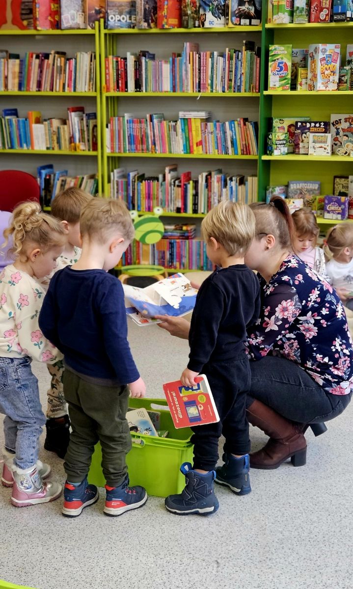 Bibliotekarka pokazuje grupie dzieci książki