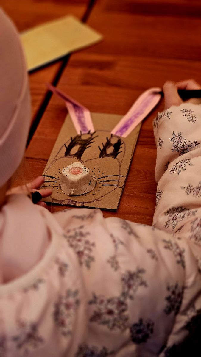 Dziewczynka wykonuje kartkę z zającem.