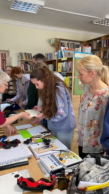 Młodzież ogląda urządzenia pomagające osobom niewidomym