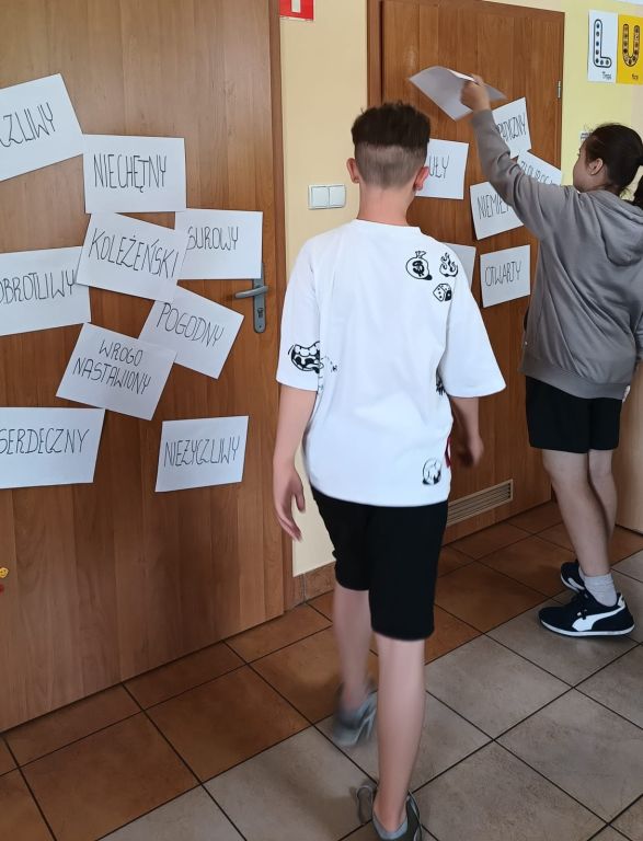Chłopcy przyklejają kartki z odpowiedziami