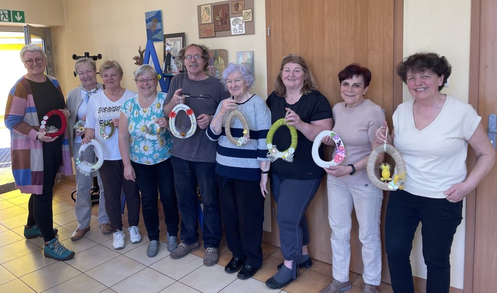 Seniorzy prezentują swoje wielkanocne zawieszki w formie jajka wykonane podczas warsztatów